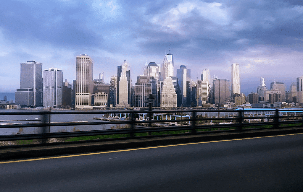 Image shows the New York City skyscape under a clody sky.