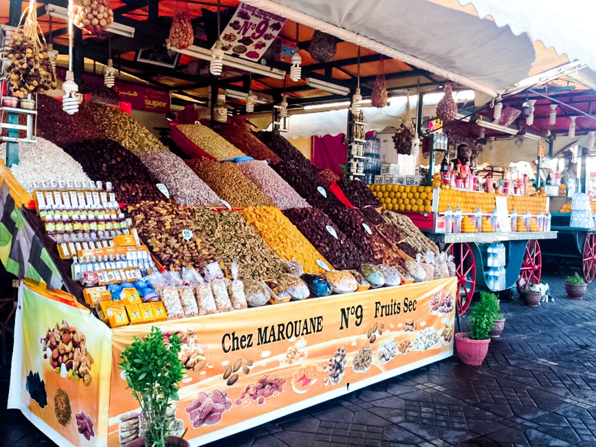 Image shows a fruit and nut cart piled high with figs, almonds and other treats.